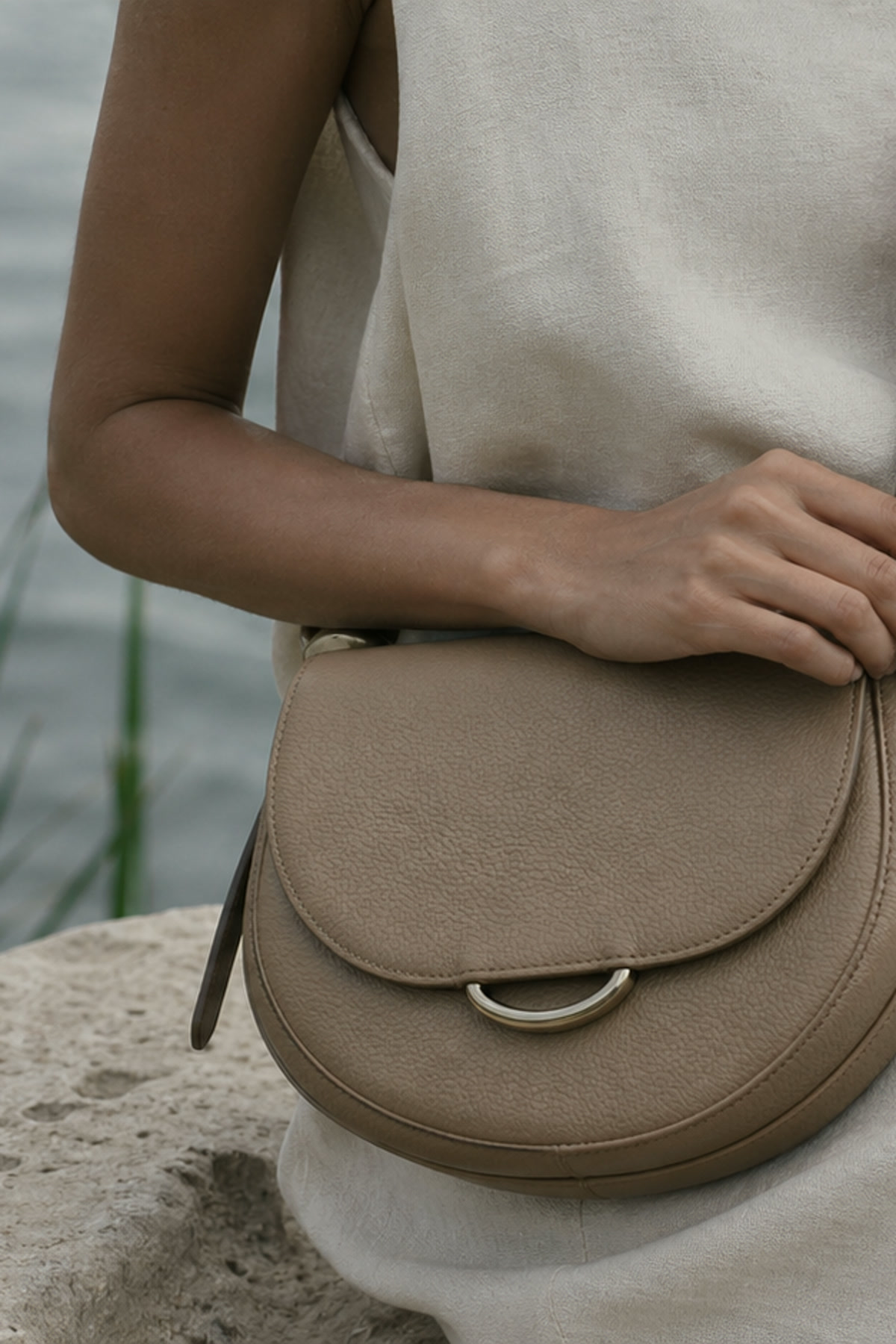 AELA model carrying a black leather handbag